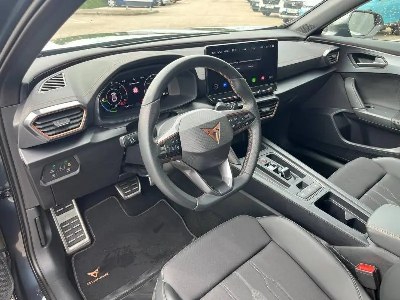Intérieur du CUPRA Formentor 1.4 e-HYBRID 2024 vu côté conducteur, volant sport cuir et écran tactile HD.