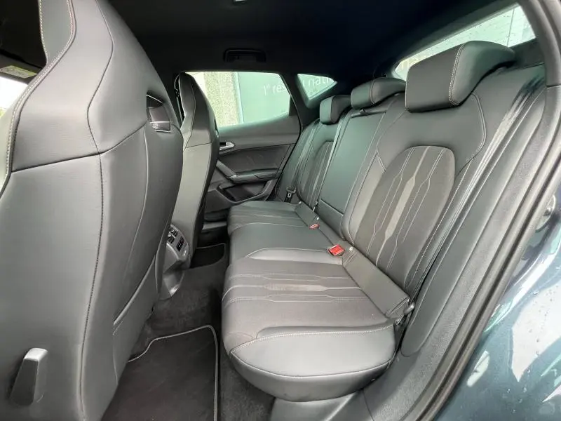 Vue latérale droite de l'habitacle arrière du CUPRA Formentor 2024 avec sièges sport en tissu et similicuir noir.