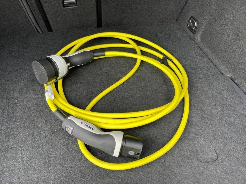 Câble de recharge jaune enroulé dans le coffre gris du CUPRA Formentor 1.4 e-HYBRID 2024.