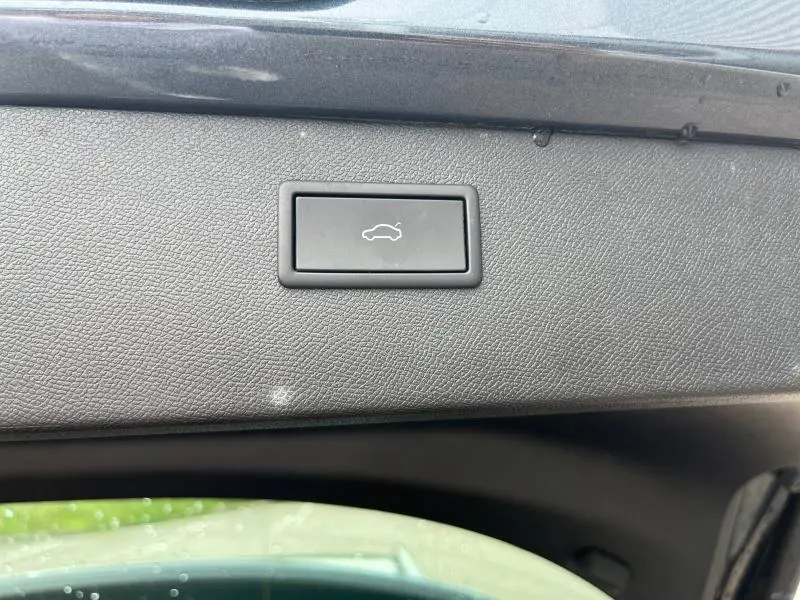 Bouton noir d'ouverture électrique du hayon sur la garniture intérieure du coffre du CUPRA Formentor gris Magnétique 2024