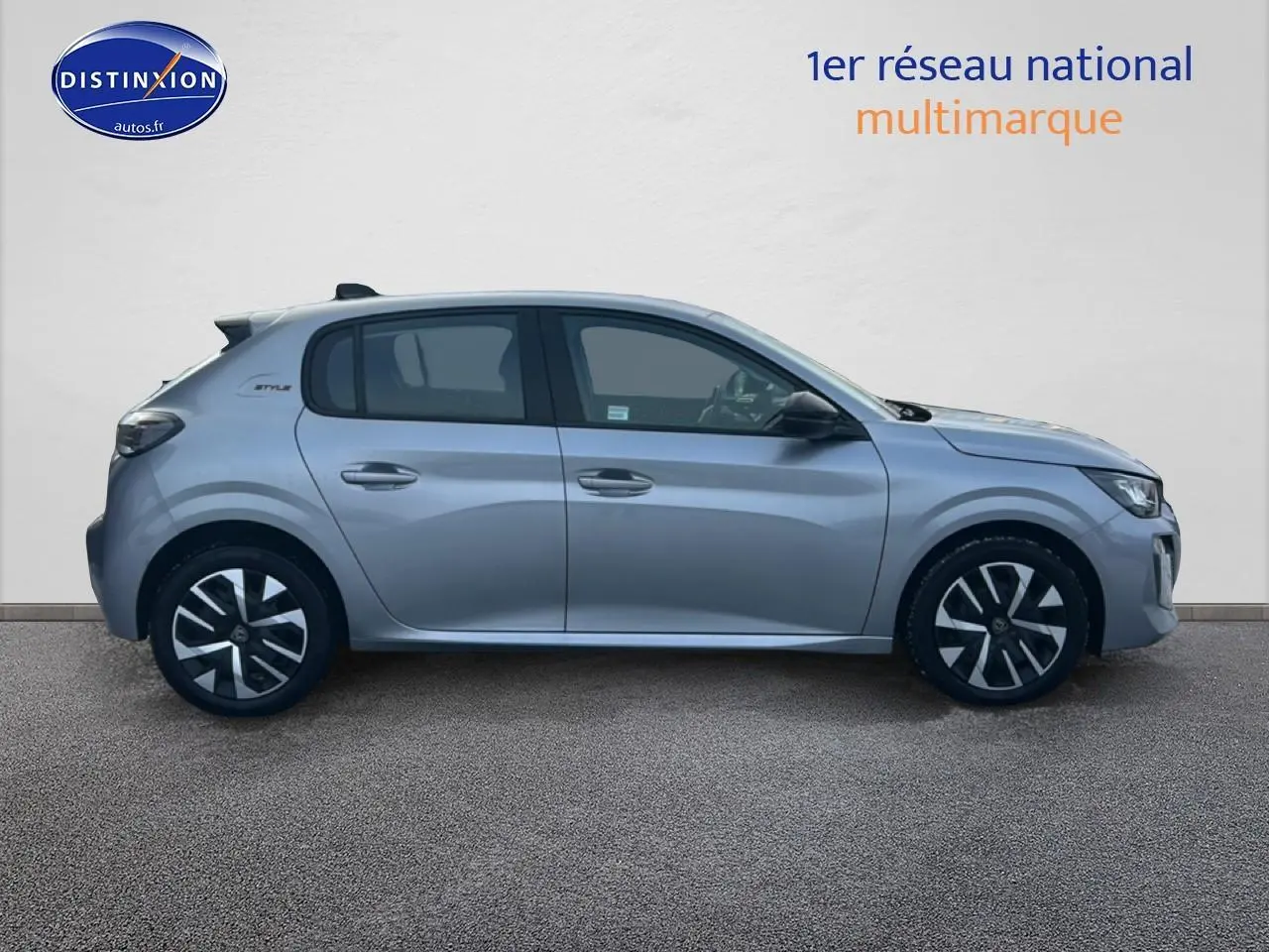 Profil côté gauche d'une Peugeot 208 1.2 100 Style gris Artense avec jantes noires et grises, sur fond neutre.