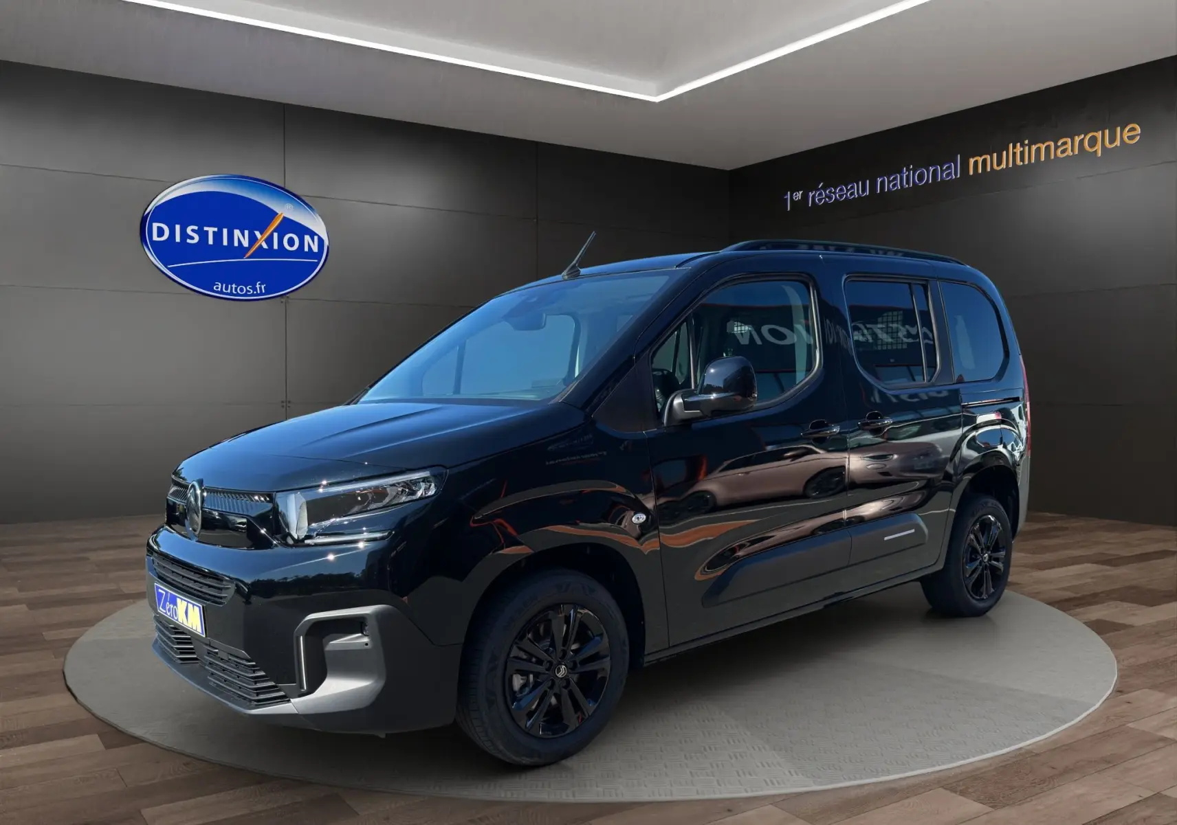 Vue 3/4 avant droit d'un Citroën Berlingo noir 2025 avec jantes alliage noires et barres de toit.