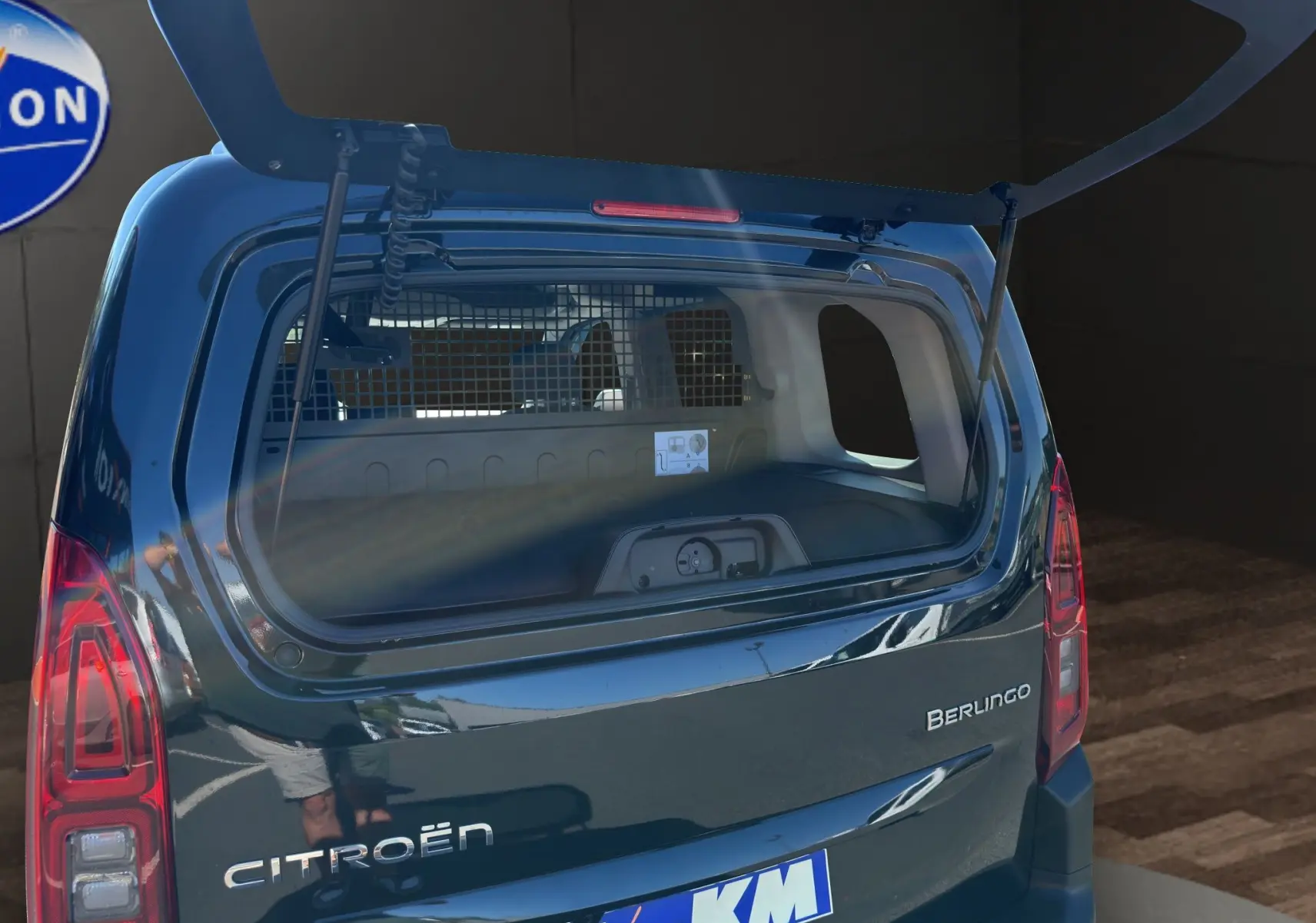 Vue arrière du Citroën Berlingo noir 2025 avec hayon ouvert et grille de séparation visible dans le coffre.