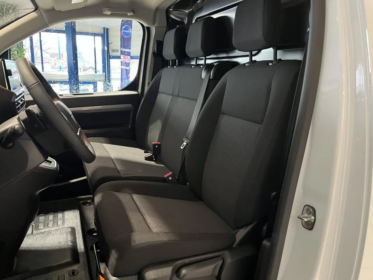 Vue intérieure côté droit montrant les sièges avant noirs du Peugeot Expert Fourgon blanc 2024.
