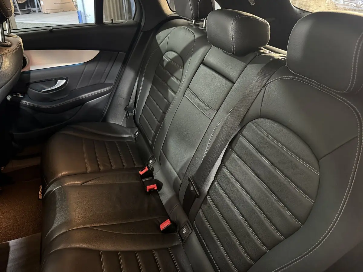 Vue intérieure côté droit des sièges arrière en cuir noir du Mercedes GLC 250 Fascination 2019 avec ceintures visibles.
