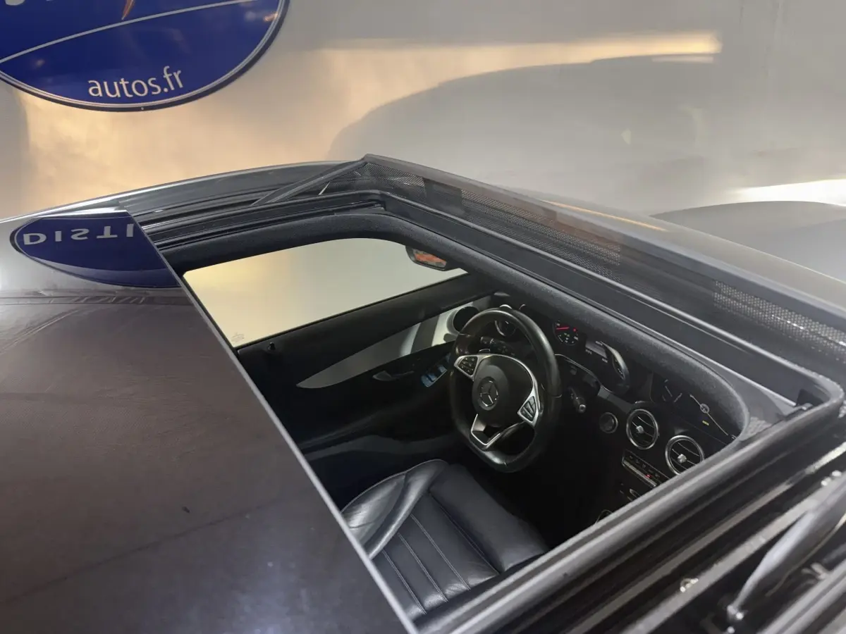 Vue plongeante sur l'intérieur noir d'un Mercedes GLC 250 Fascination 4Matic 2019 via toit ouvrant ouvert.