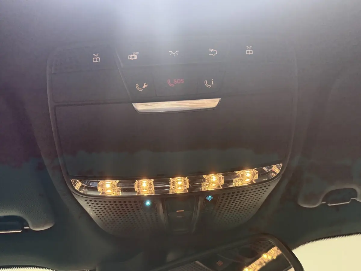 Plafonnier intérieur avec commandes SOS et éclairage ambiant dans un Mercedes GLC 250 Fascination gris foncé, vue de dessous.