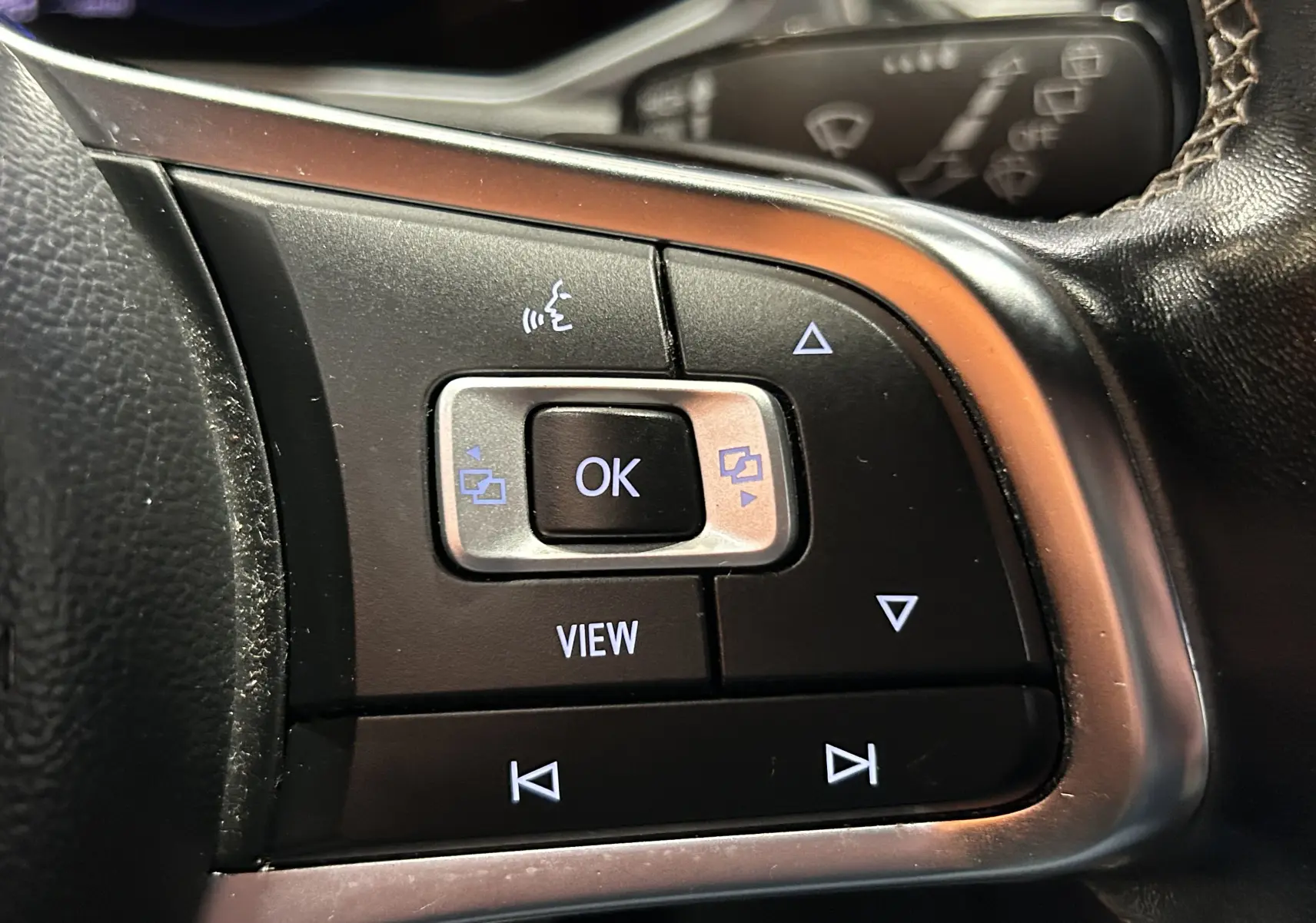 Gros plan sur les commandes multifonctions noires du volant côté gauche du Volkswagen T-Roc noir 2020.
