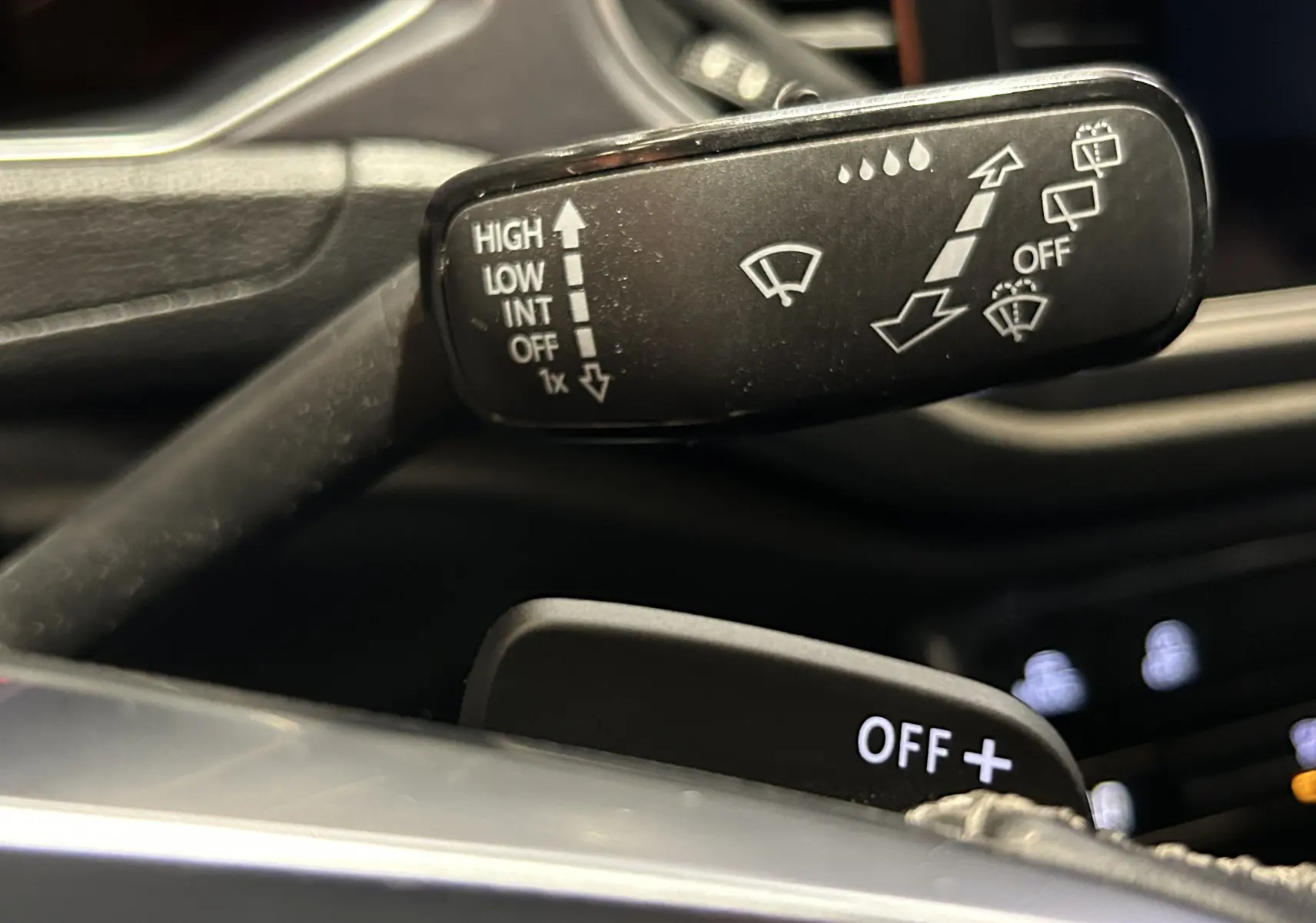 Gros plan sur la commande des essuie-glaces du Volkswagen T-Roc noir, vue intérieure côté conducteur.