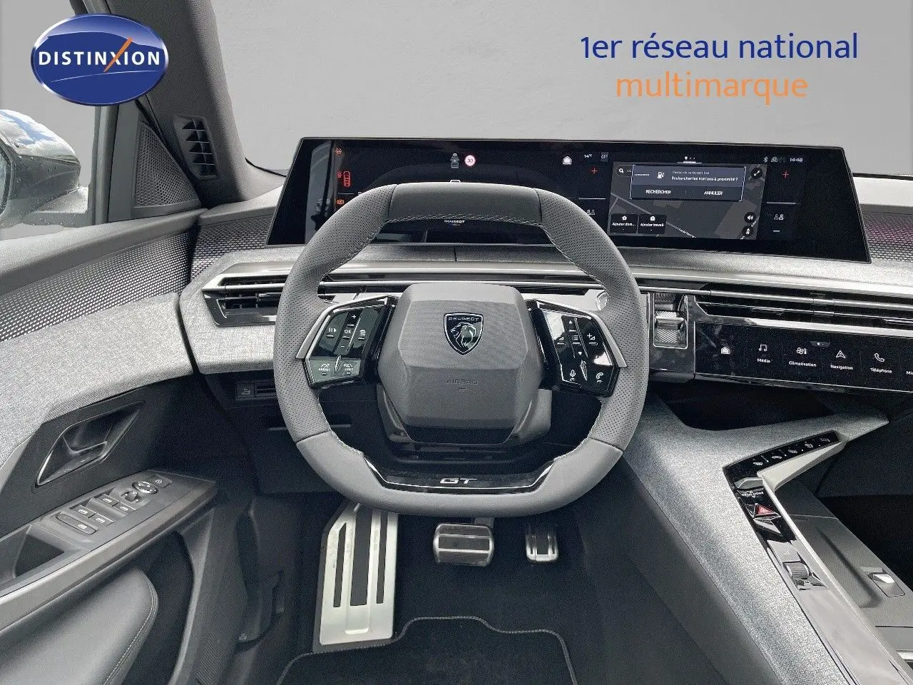 Vue intérieure frontale du tableau de bord et volant gris perforé du Peugeot 5008 Hybrid GT 2025 avec écran numérique panoramique.