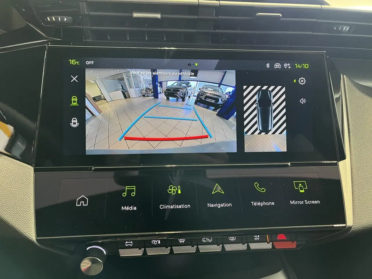 Écran tactile central de la Peugeot 308 SW blanc okenite montrant la caméra de recul en intérieur de garage.