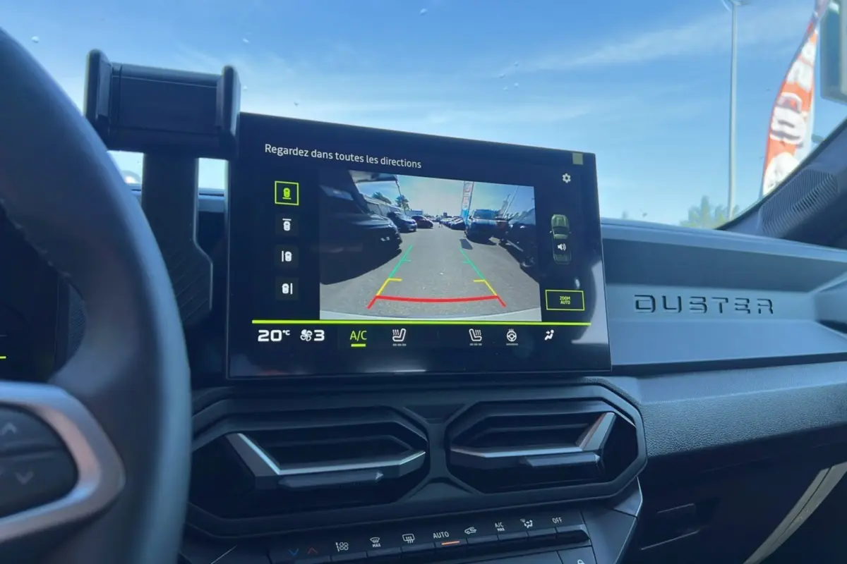 Vue intérieure du tableau de bord du Dacia Duster 2025 avec écran multimédia affichant la caméra de recul.