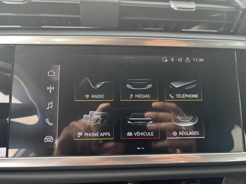 Écran tactile central de l'Audi Q3 2022 montrant les options radio, médias, téléphone et réglages du véhicule.