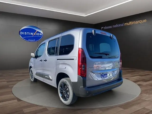 Vue 3/4 arrière droite du Citroën Berlingo gris Artense avec jantes alliage noires et vitres teintées foncées.