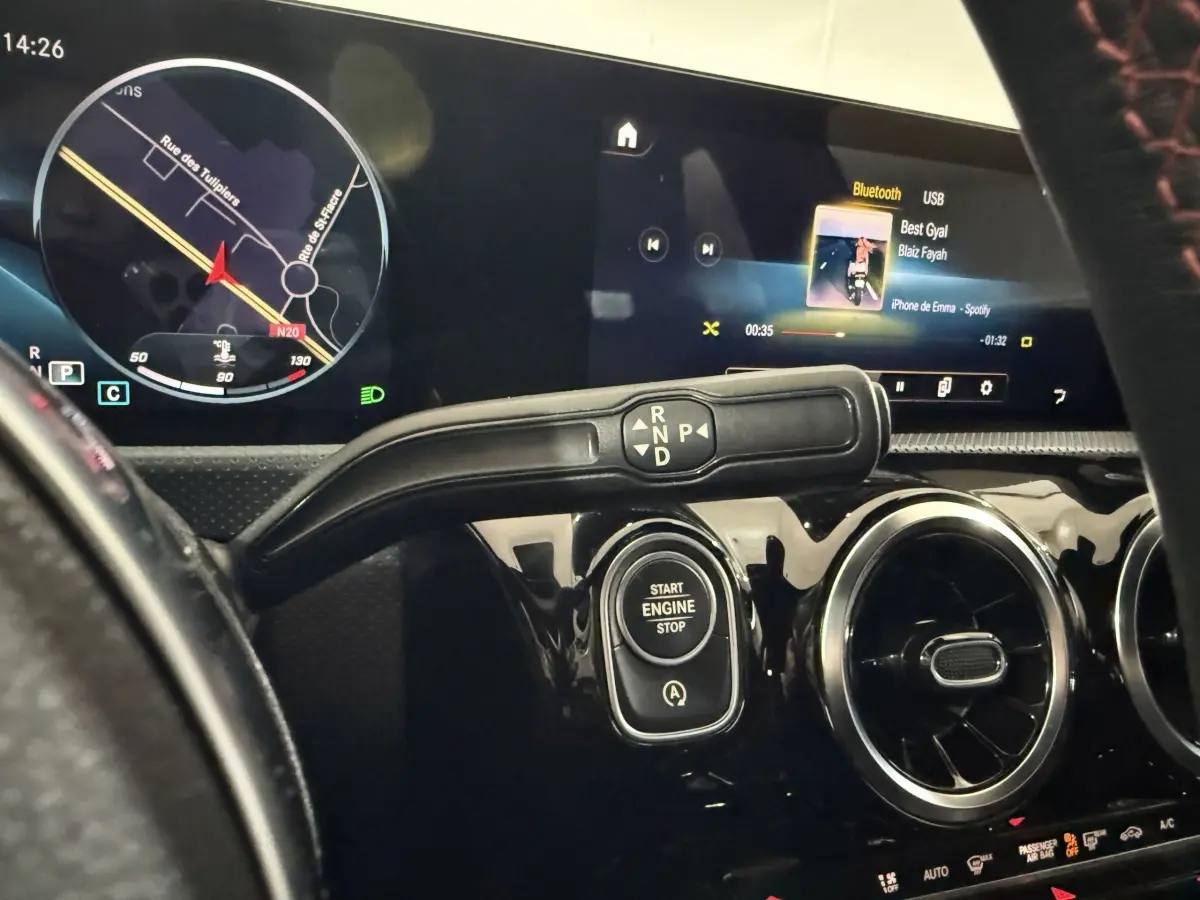 Vue rapprochée de l'intérieur de la Mercedes Classe A 200 AMG Line 2021, tableau de bord noir avec écran tactile et bouton start/stop.