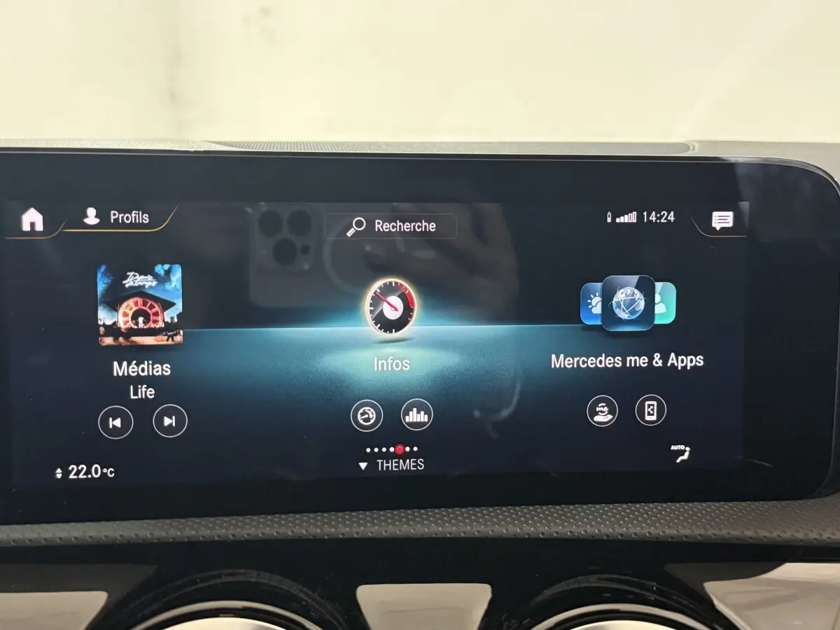 Écran tactile central de la Mercedes Classe A 200 AMG Line 2021 affichant médias, infos et applications, vue intérieure frontale.