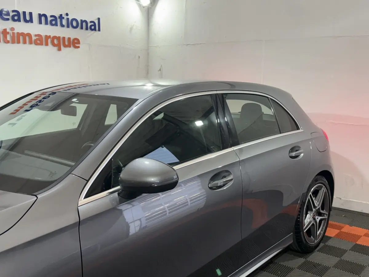 Vue latérale gauche d'une Mercedes Classe A 200 AMG Line gris foncé avec jantes alliage et rétroviseur assorti.