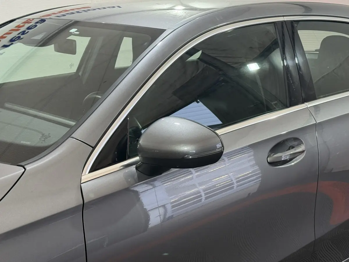 Vue latérale côté gauche sur la porte avant et le rétroviseur gris foncé métallisé d'une Mercedes Classe A AMG Line 2021.