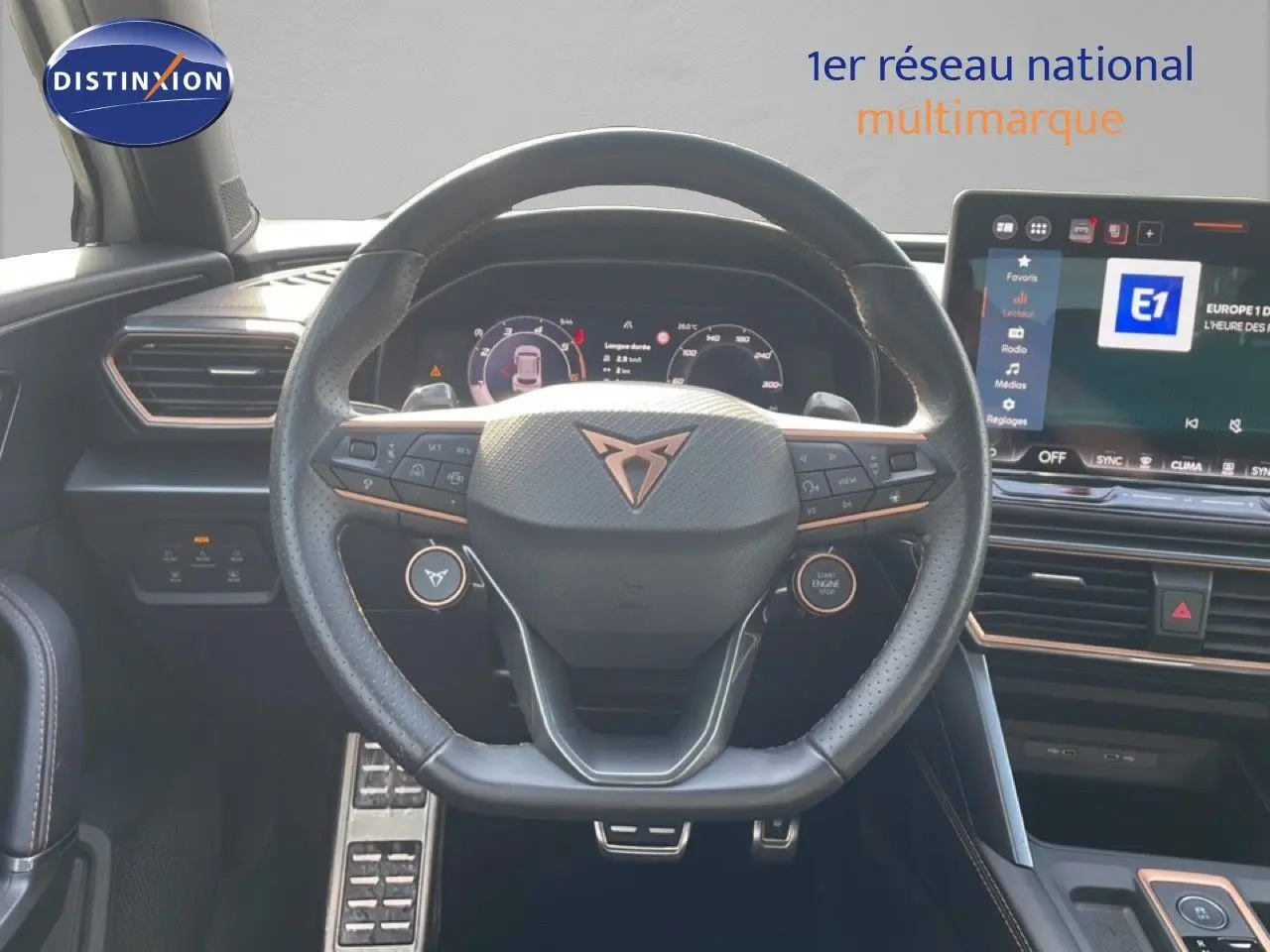 Vue intérieure centrée sur le volant cuir noir et la planche de bord avec écran tactile du CUPRA Formentor blanc neige métal 2025.