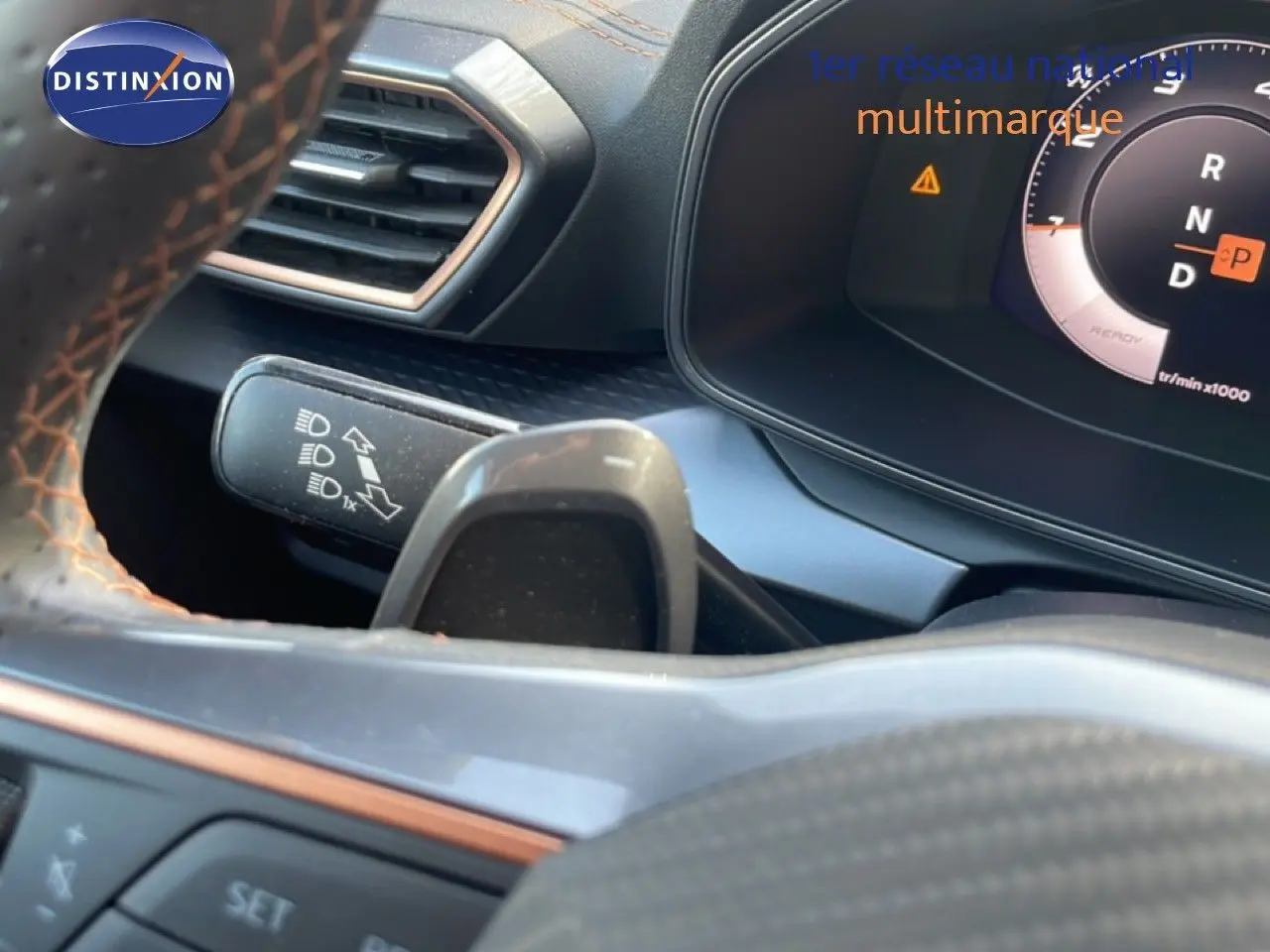 Gros plan sur le volant et le combiné d'instruments du CUPRA Formentor blanc neige métal, affichant la boîte auto en position parking.