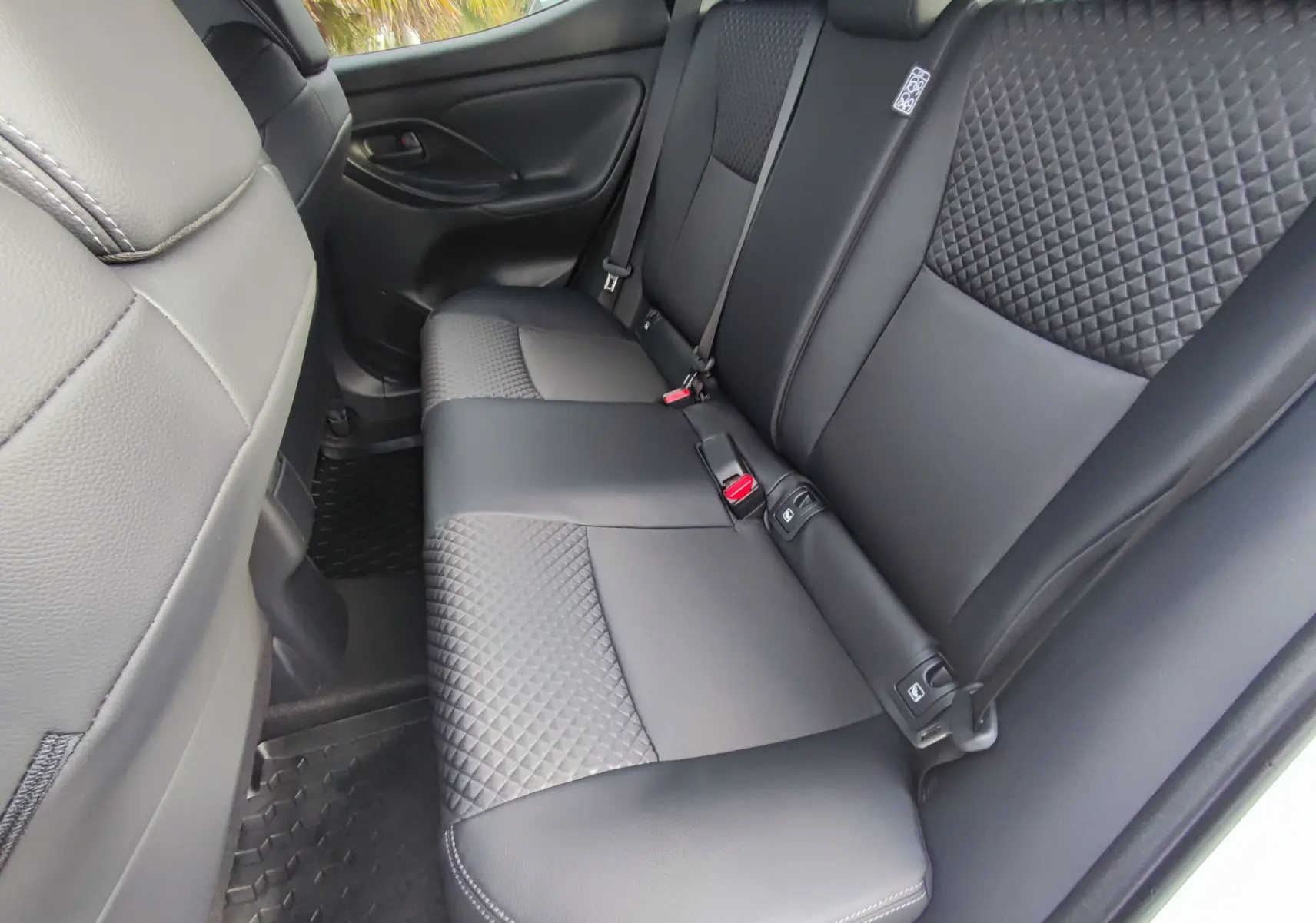 Vue intérieure arrière côté droit des sièges en cuir noir matelassé de la Mazda2 Hybrid 2024 blanc métallisé.