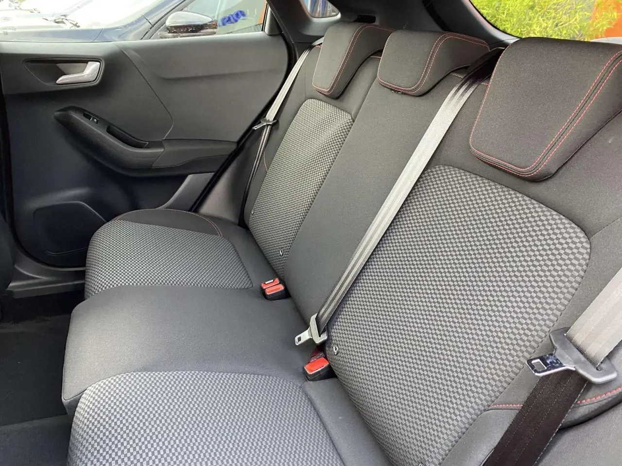 Banquette arrière vue côté gauche du Ford Puma 2022 avec sellerie tissu gris à surpiqûres rouges.