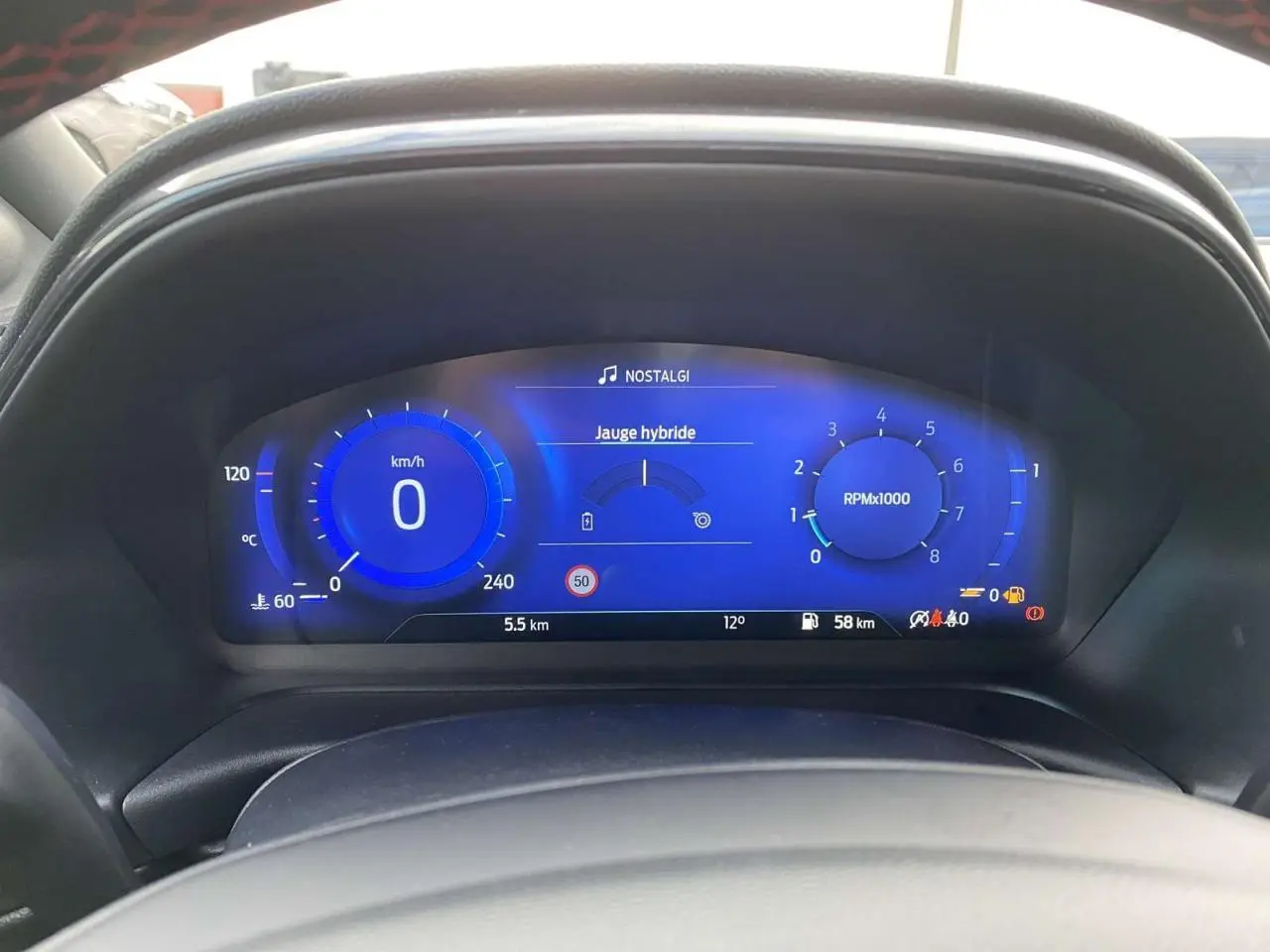 Tableau de bord numérique bleu du Ford Puma 1.0 EcoBoost MHEV 2022 affichant vitesse, compte-tours et jauge hybride.