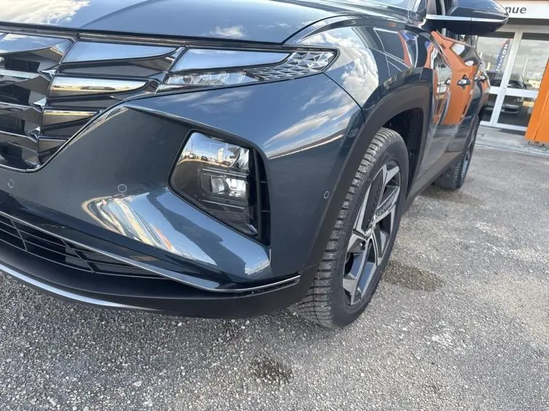 Gros plan sur l'avant droit du Hyundai Tucson Teal Blue Métal, mettant en valeur la calandre chromée et les phares LED.