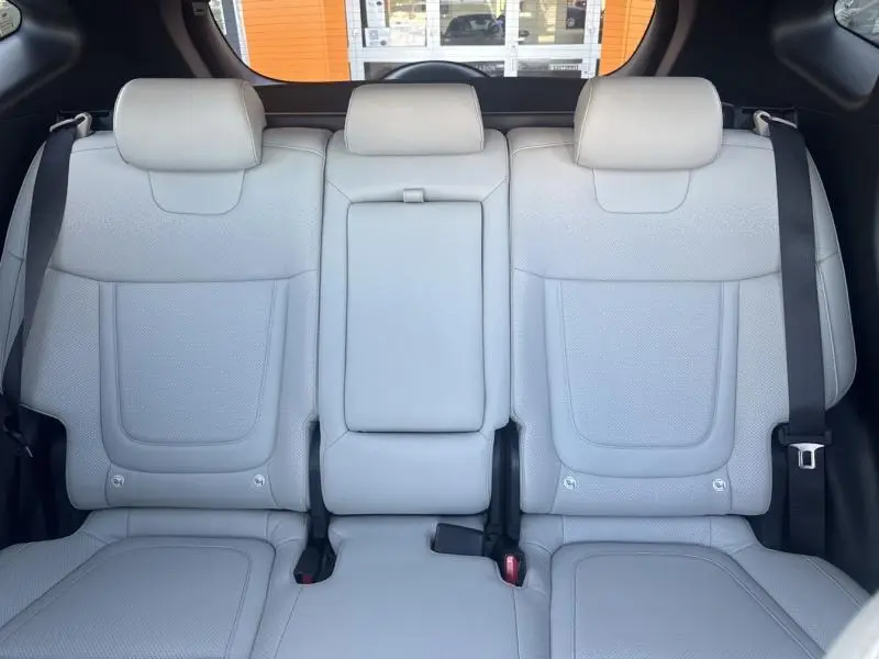 Banquette arrière en cuir gris clair du Hyundai Tucson 2021 vue de face avec appuie-têtes et ceintures de sécurité visibles.