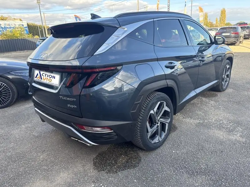 Vue 3/4 arrière droite d'un Hyundai Tucson Teal Blue Métal avec feux arrière LED et jantes alliage modernes.