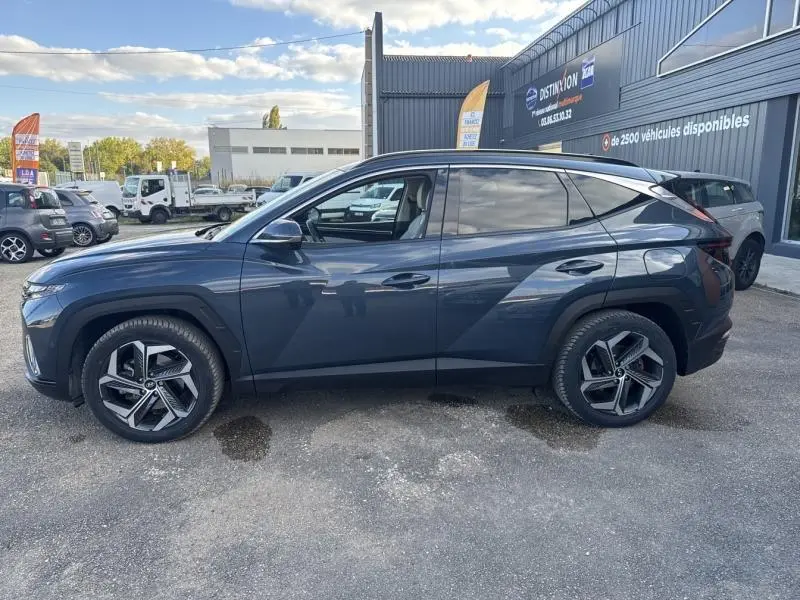 Vue de profil côté gauche d'un Hyundai Tucson 2021 Teal Blue Métal avec jantes alliage et vitres surteintées.