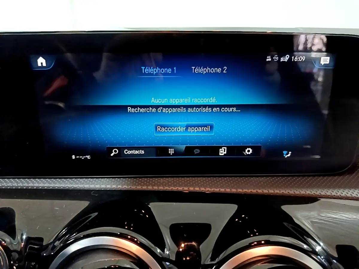 Écran tactile central bleu affichant la connexion Bluetooth dans le tableau de bord noir brillant d'une Mercedes Classe A A 200 AMG Line.