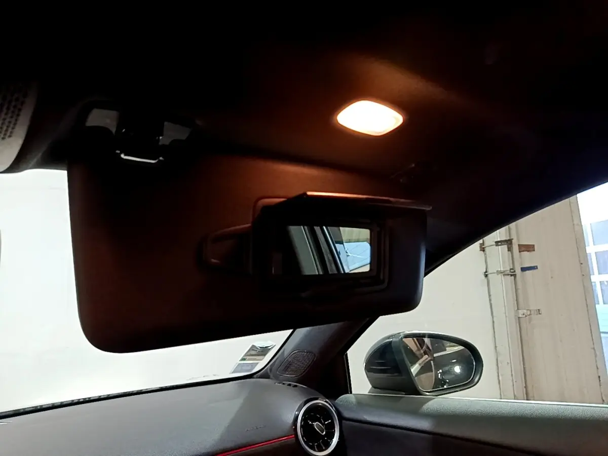 Intérieur noir de la Mercedes Classe A 200 AMG Line 2021, vue sur pare-soleil avec miroir et rétroviseur côté gauche.
