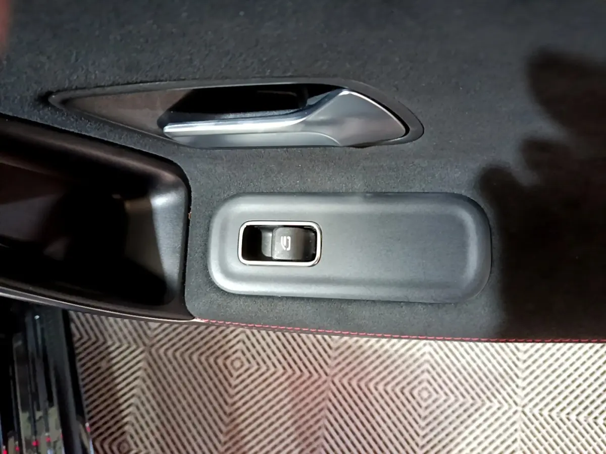 Détail de la commande de vitre électrique sur la porte intérieure noire d’une Mercedes Classe A 200 AMG Line 2021.