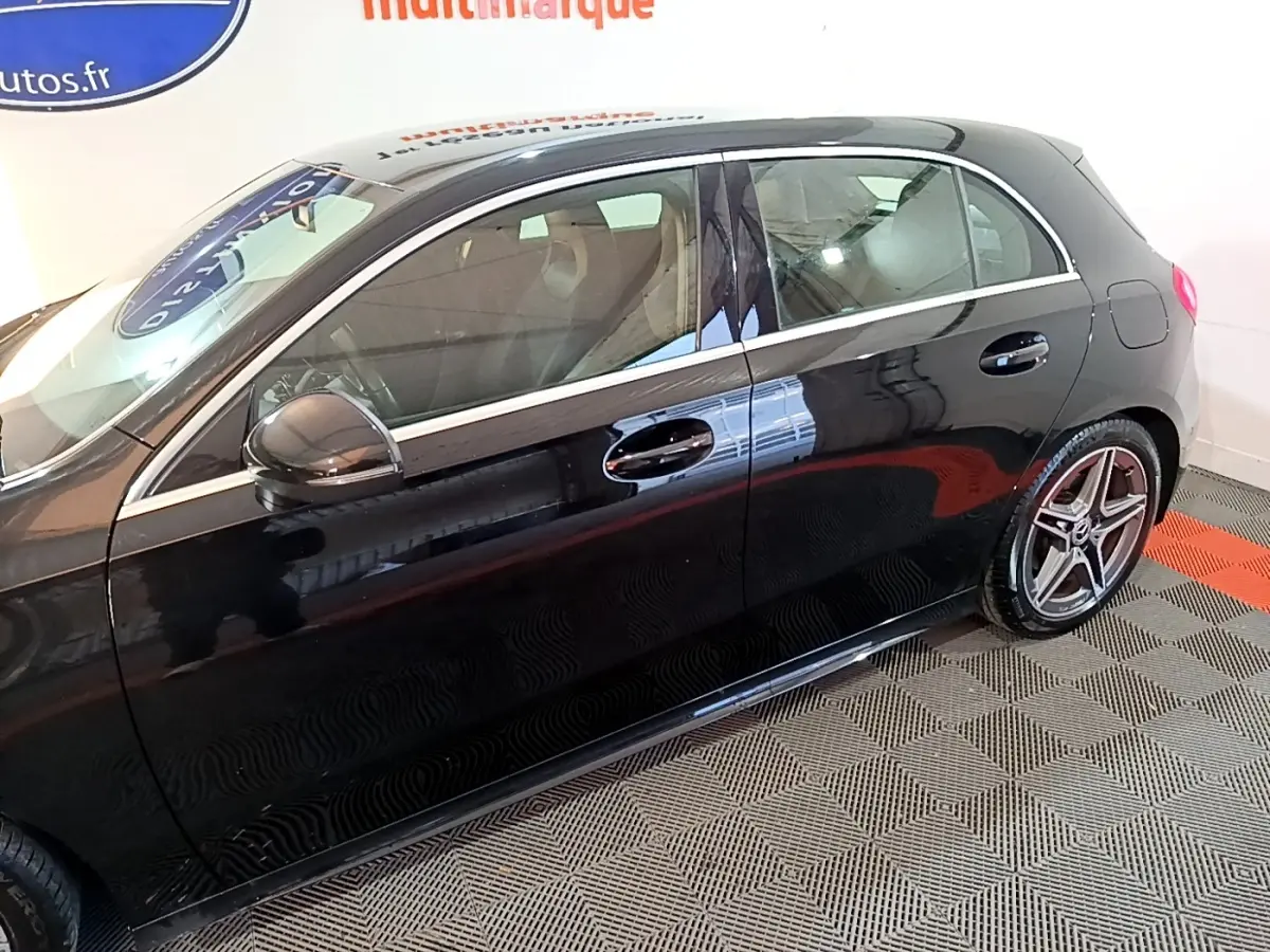 Vue de profil côté gauche d'une Mercedes Classe A 200 AMG Line noire avec jantes sport et rétroviseurs noirs.
