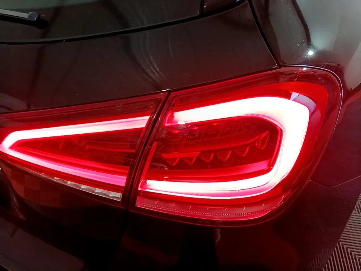 Gros plan sur le feu arrière droit allumé d’une Mercedes Classe A 200 AMG Line noire, finition brillante.