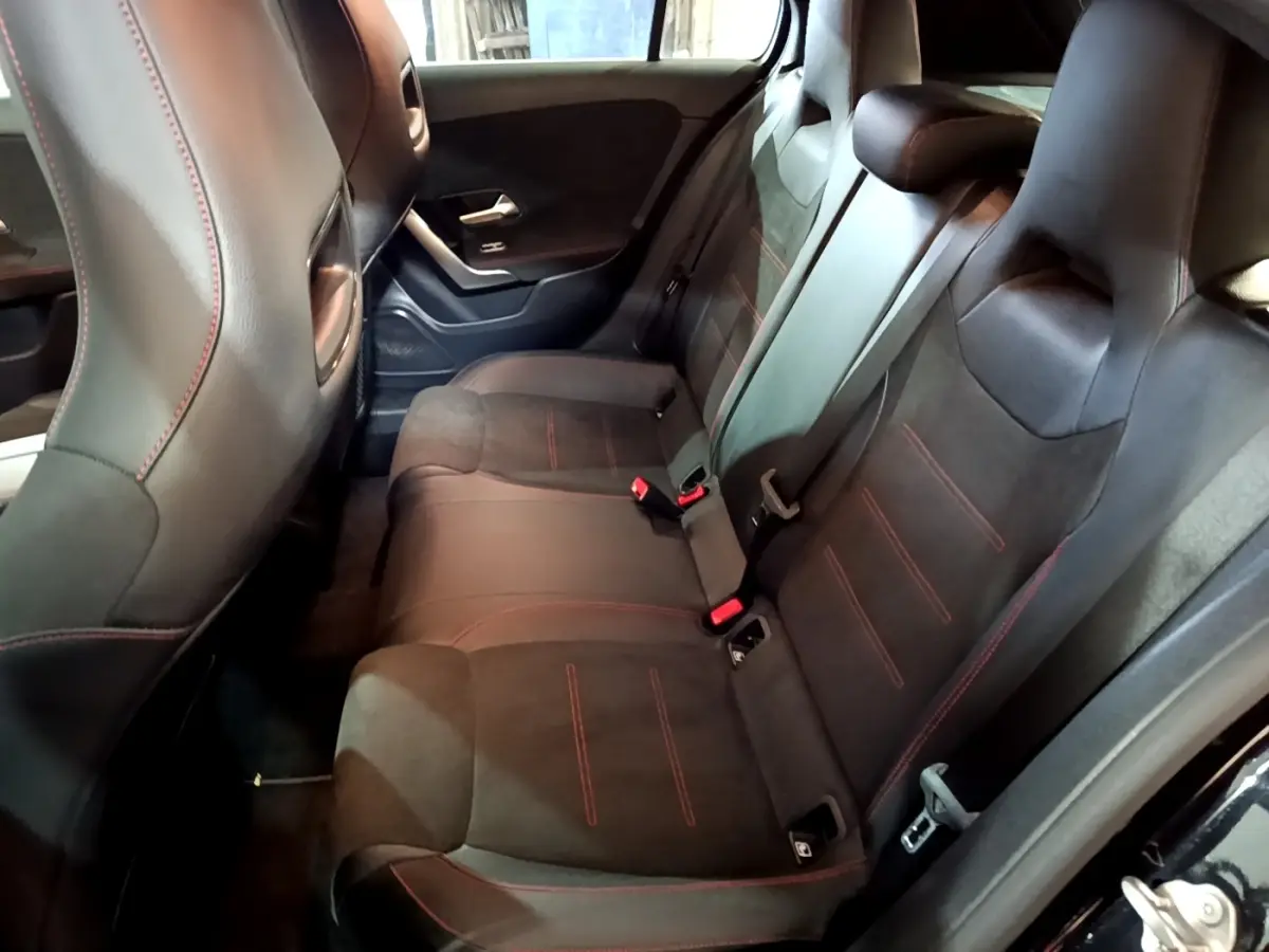 Vue intérieure côté droit des sièges arrière noirs avec surpiqûres rouges de la Mercedes Classe A A 200 AMG Line 2021.