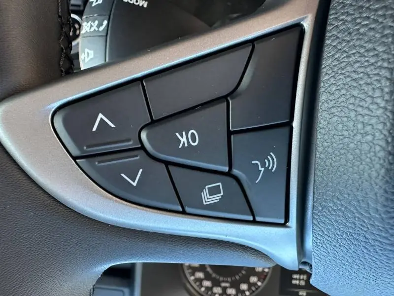 Gros plan sur les commandes multifonctions noires du volant côté gauche du Dacia Jogger 2024 Noir Nacré métallisé.