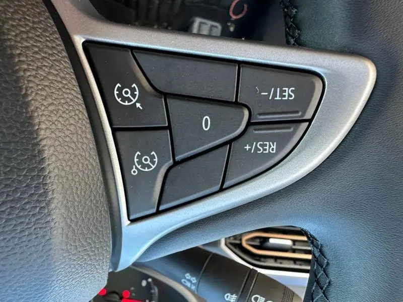 Gros plan sur les commandes de régulateur de vitesse au volant noir du Dacia Jogger 2024 finition Extreme.