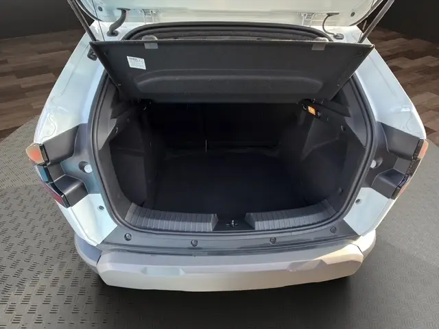 Coffre ouvert vu de l'arrière d'un Dacia Duster blanc 2025, montrant l'espace de chargement vide et la tablette de coffre.