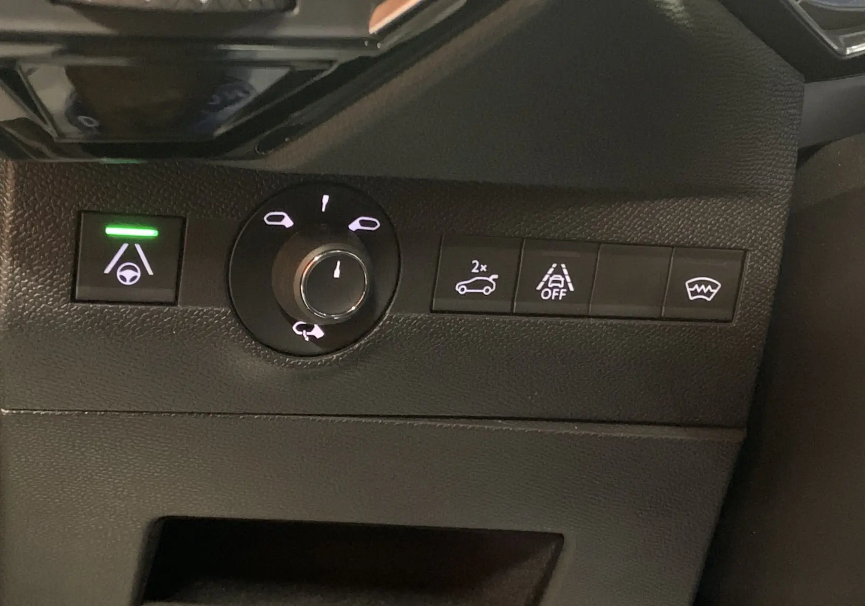 Gros plan sur les commandes de sécurité et éclairage du tableau de bord du DS7 Crossback gris Platinium 2022.