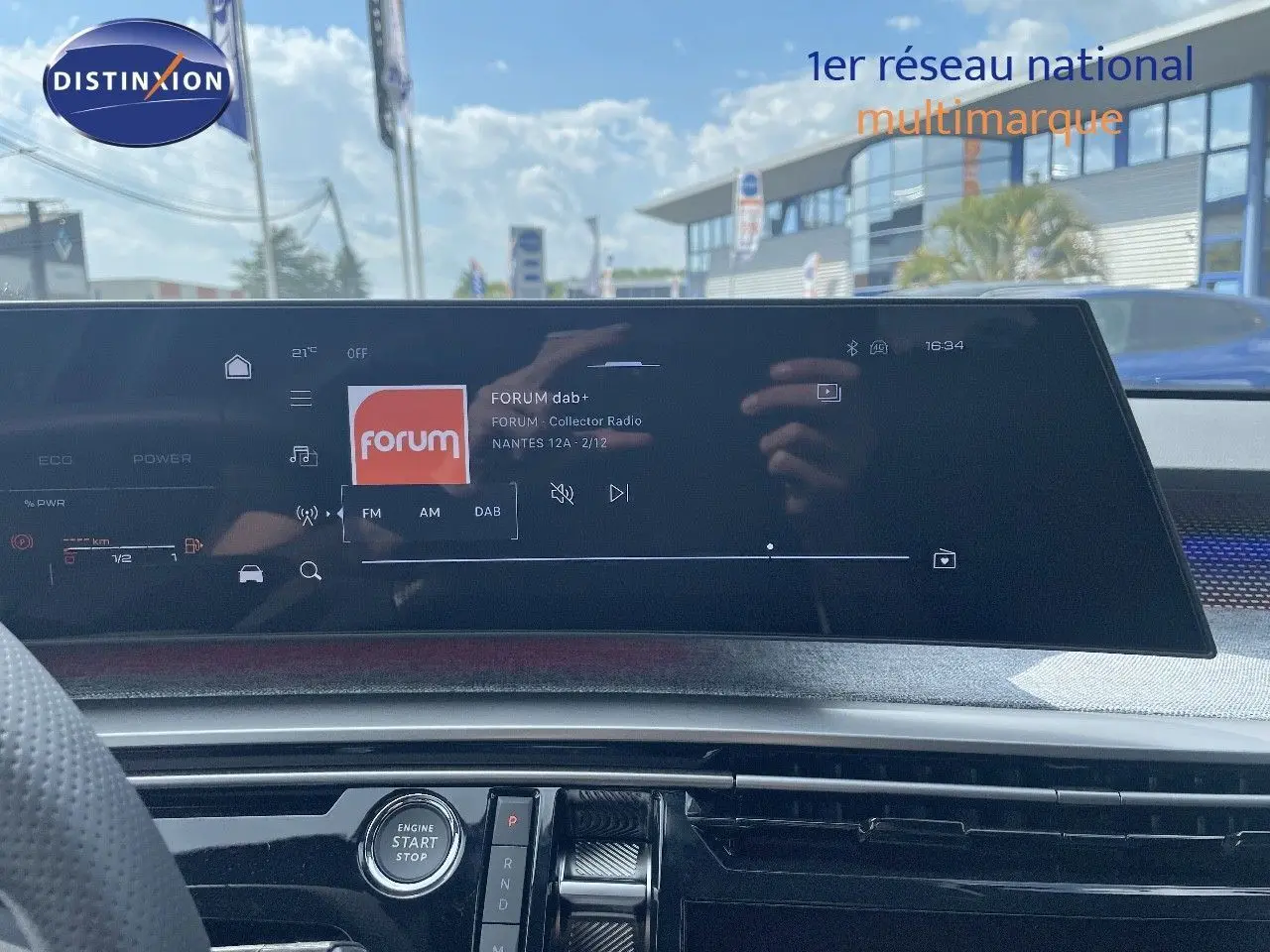 Vue intérieure du tableau de bord du Peugeot 5008 Hybrid 136ch GT 2025, écran tactile affichant une radio numérique.