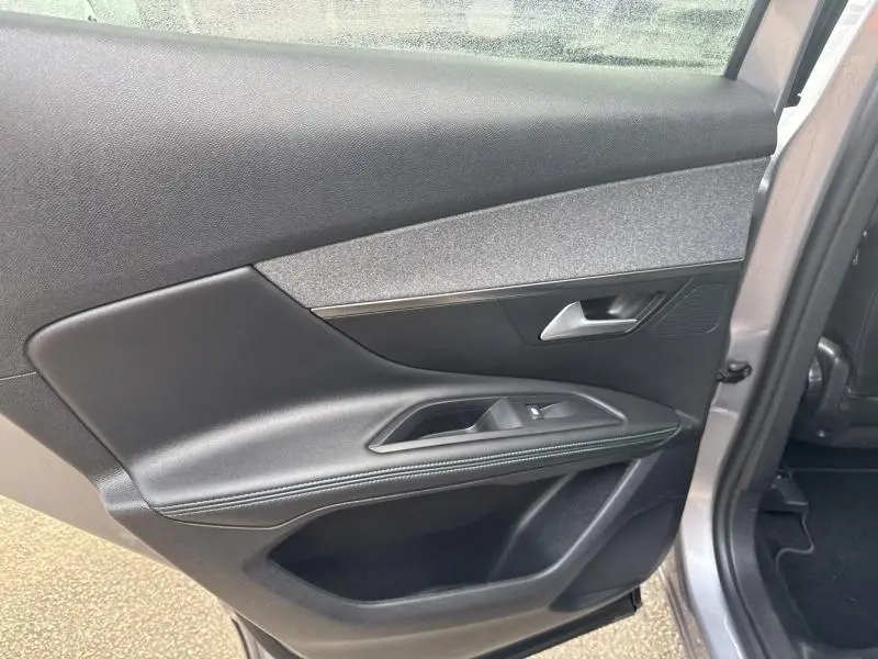 Gros plan sur la porte arrière droite gris Artense du Peugeot 3008 2022 avec garniture tissu et commandes de vitre intégrées.