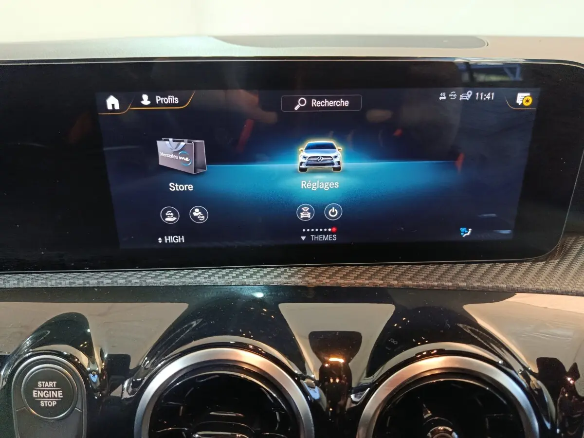 Écran tactile central du tableau de bord de la Mercedes Classe A 250 e Business Line bleu, avec commandes et bouton start/stop visibles.