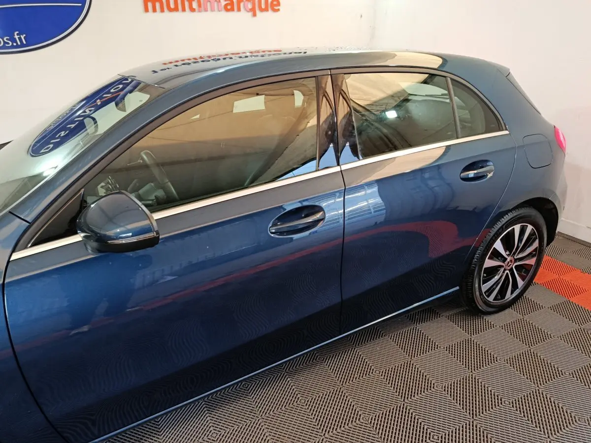 Vue latérale côté gauche d'une Mercedes Classe A 250 e Business Line bleu avec jantes alliage et rétroviseur assorti.