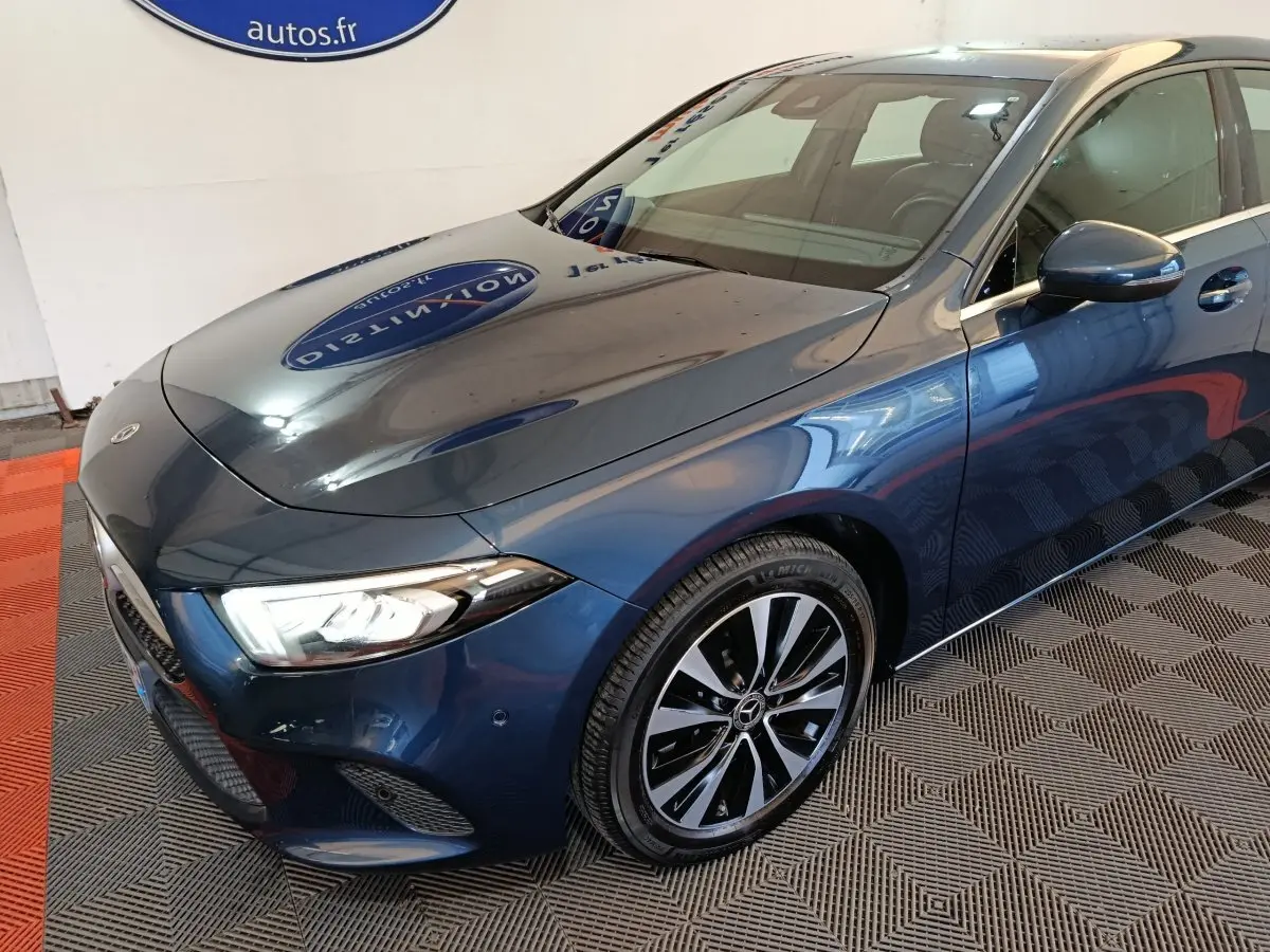 Vue 3/4 avant droit d'une Mercedes Classe A 250 e Business Line hybride rechargeable bleu métallisé avec jantes alliage bicolores.