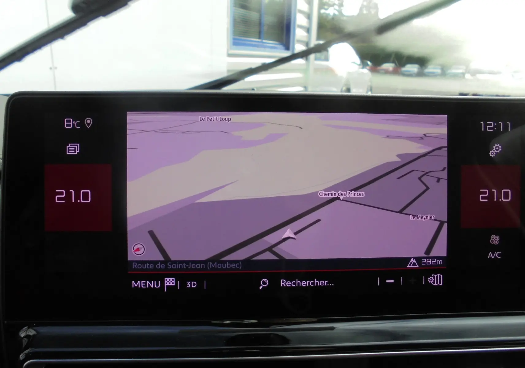 Écran tactile central du tableau de bord du Citroën C5 Aircross blanc, affichant la navigation GPS en plein jour.