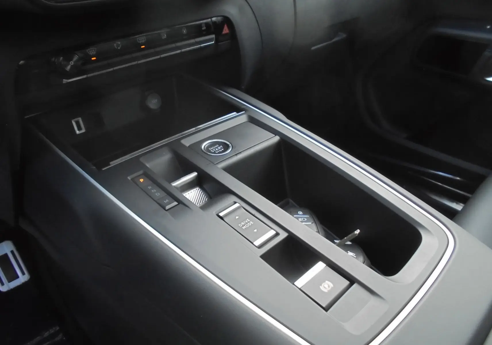 Vue rapprochée de la console centrale noire du Citroën C5 Aircross 2022 avec bouton start, levier de vitesses et rangement.