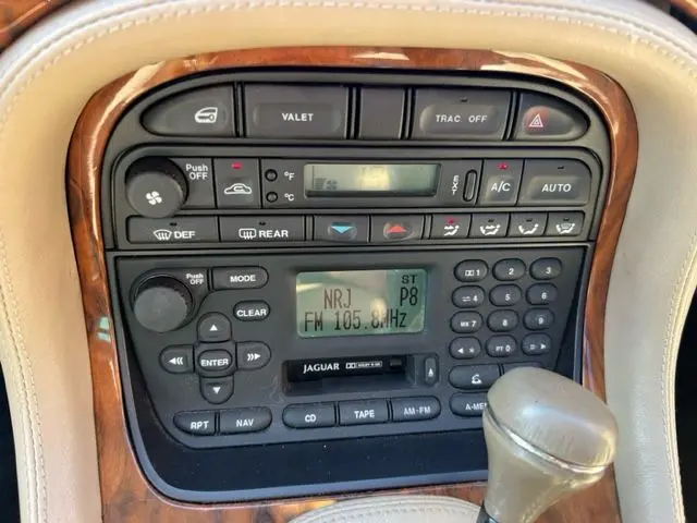 Console centrale en bois du Jaguar Sovereign 3.2 V8 2002, avec radio et commandes climatisation visibles.