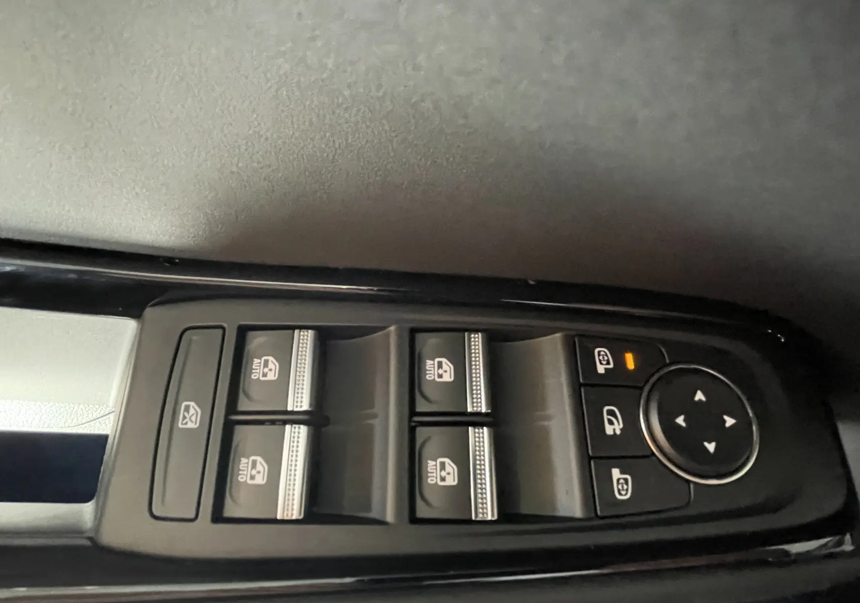 Gros plan sur les commandes de lève-vitres et réglages des rétroviseurs côté conducteur du Renault Rafale gris shiste 2024.